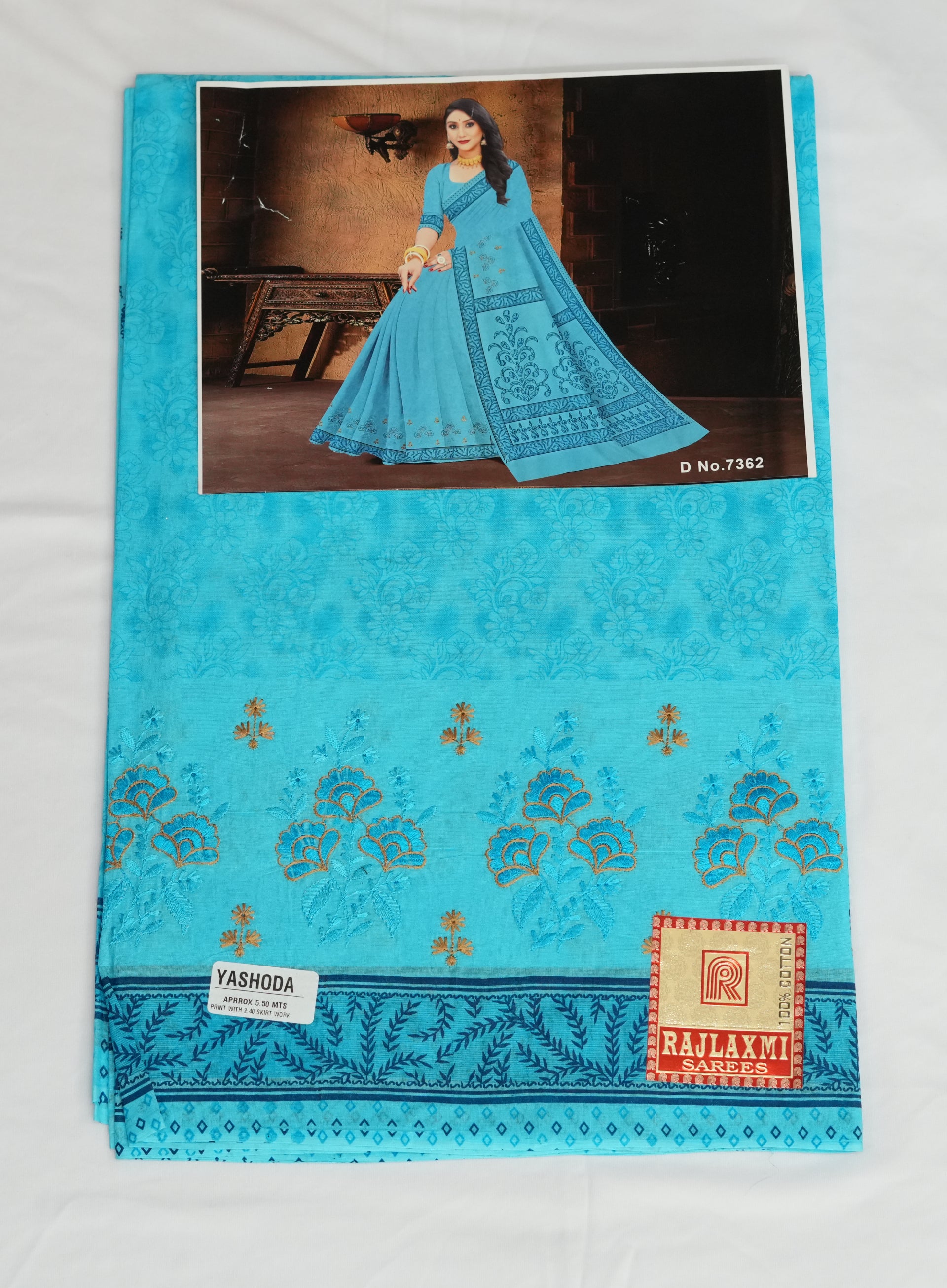 Blue embroidered fabric with a woman in a blue dress in the background