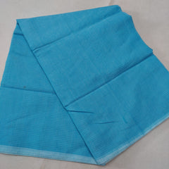 A folded blue Kota cotton plain saree with a solid pattern, displayed on a white background.