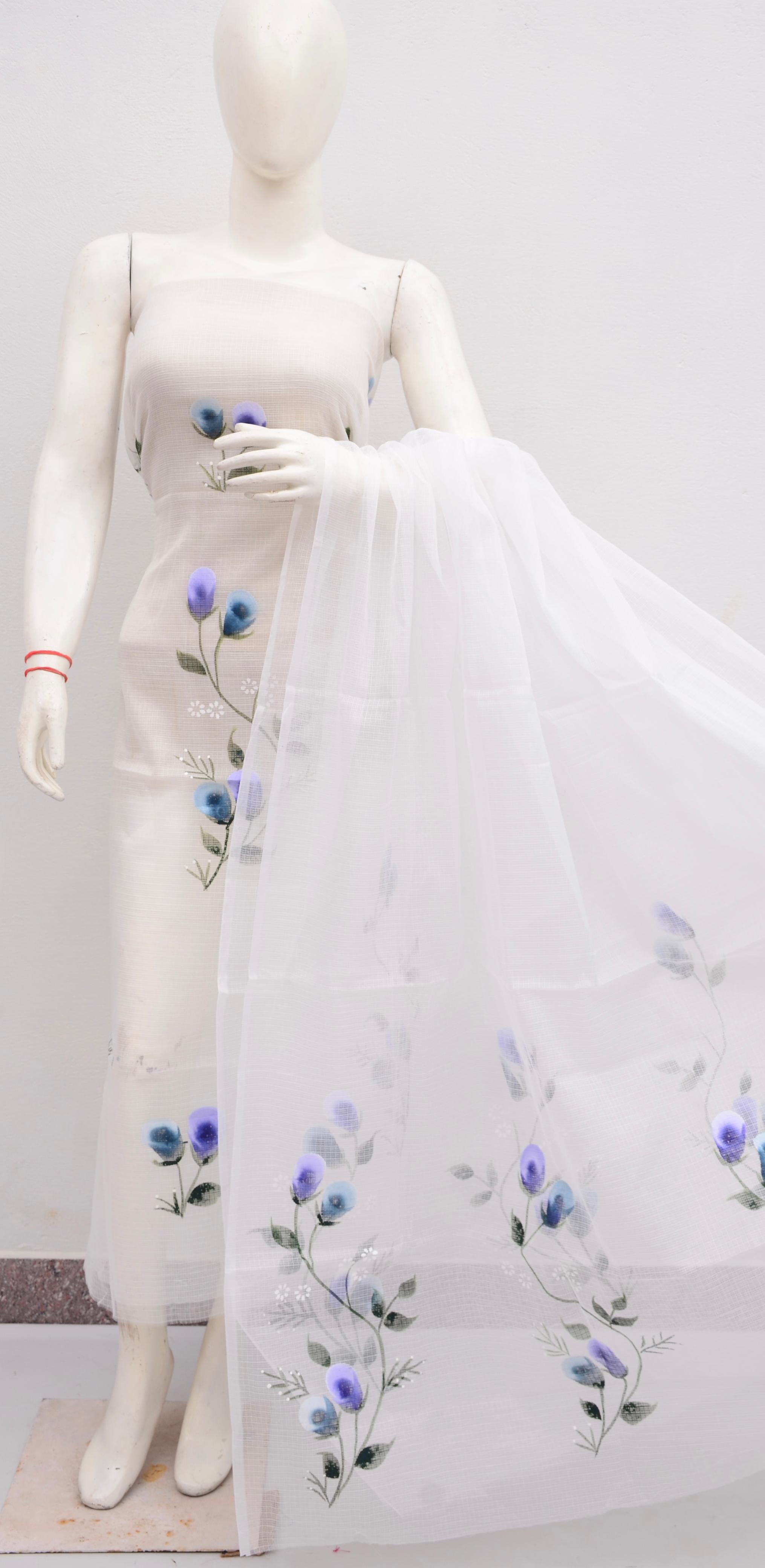 Mannequin wearing a white dress with floral embroidery on a plain background