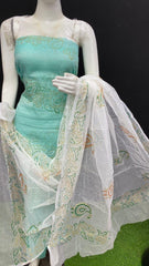 Mannequin wearing a turquoise dress with a white embroidered dupatta on a black background