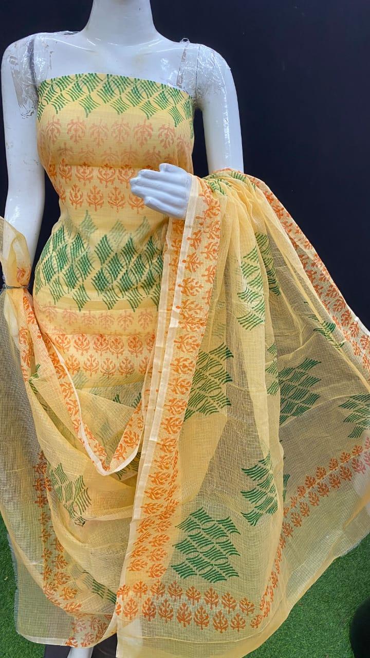 Mannequin wearing a yellow saree with green and orange patterns on a dark background