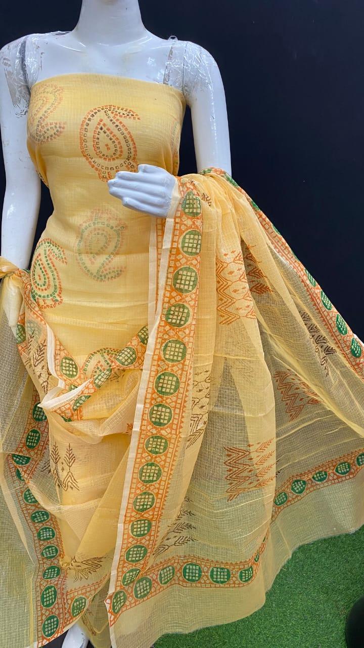 Yellow saree with green and orange patterns on a mannequin against a dark background