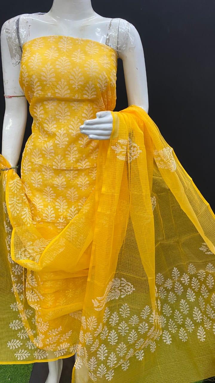 Yellow embroidered dress with a matching dupatta on a mannequin against a black background