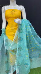 Yellow dress with green dupatta on a mannequin against a black background
