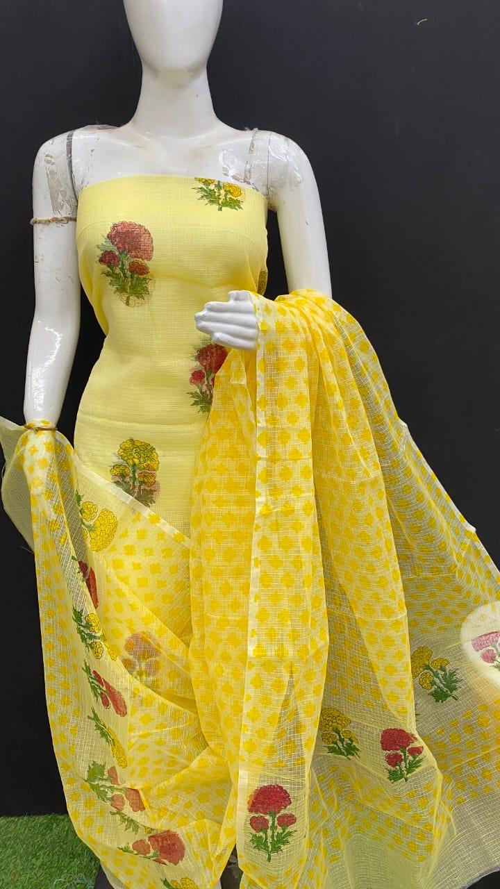 Mannequin wearing a yellow floral dress with a matching scarf on a black background