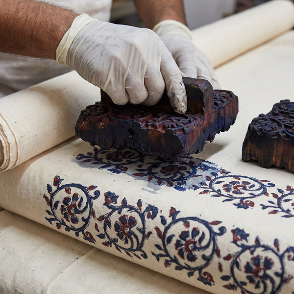 Wooden hand block printing a floral motif on cotton